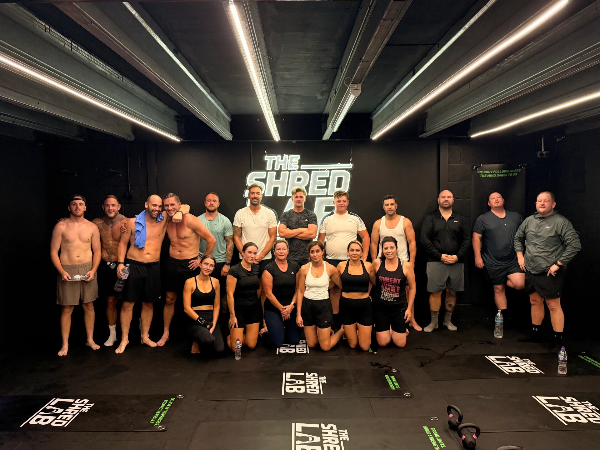 Shred Lab members together in the studio under the neon sign